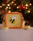 A yellow silicone bag with an orange trim and a bee design.
