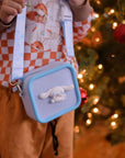 A child wears a light purple silicone Cinnamoroll bag with a blue trim and strap.
