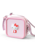 A pink square silicone bag with a 3D Hello Kitty design and a patterned strap.