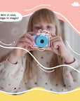 A child holding and aiming the kiimento Model A Cinnamoroll kids' digital camera, with playful graphic overlays and the caption “Mini in size, mega in magic!”.