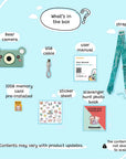 A green bear-shaped digital camera and its accessories are displayed on a light blue background.
