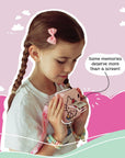 Young girl using the kiimento Hello Kitty Model P kids digital camera to print a photo. The child, wearing pastel accessories and a pink bow, holds the camera close while a black-and-white photo prints out. The background features whimsical clouds and hills, with a caption that reads, “Some memories deserve more than a screen!”
