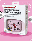 Retail packaging of the kiimento Hello Kitty Model P instant print digital camera, featuring a window showing the pastel pink camera with Hello Kitty’s face. The box highlights gift readiness, ink-free and cost-effective printing, and memory-making appeal. Tagline at the bottom reads: “Joy in every box. Memories in every click!”
