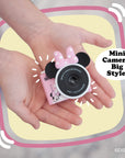 Minnie Mouse mini camera with pink bow and ears holding by kid's hands.