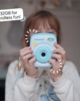A child holds a sky blue instant print camera with a speech bubble that says "32GB for endless fun!".