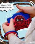 A child's hands hold a blue and red Spider-Man digital camera with a speech bubble that says "GAME-FREE ADVENTURES!".