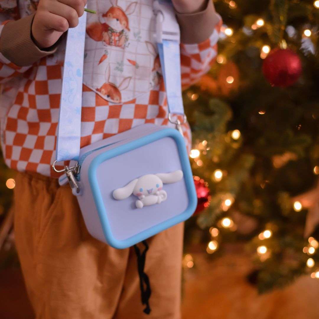 A child wears a light purple silicone Cinnamoroll bag with a blue trim and strap.