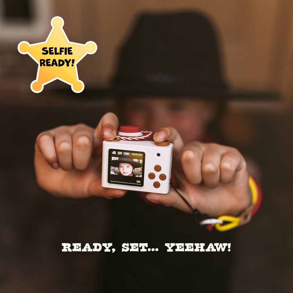 Rear view of the digital Jesie mini camera showing the digital LCD screen, a brown directional pad, brown buttons for navigation, themed filters and the selfie of a happy kid. 