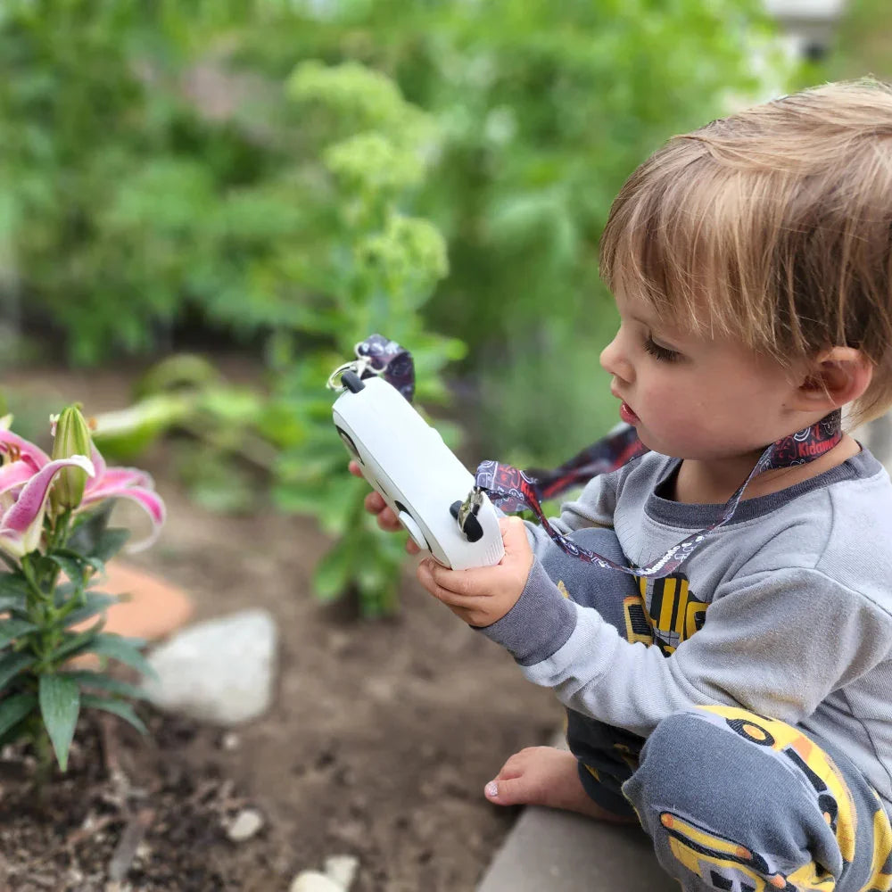 kids instant print camera boy take pictures of a flower