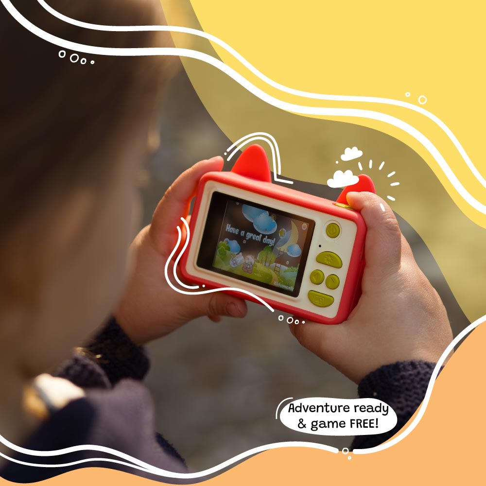 Child holding Kidamento Model C Fox camera showing back screen with fun message and kid-friendly buttons