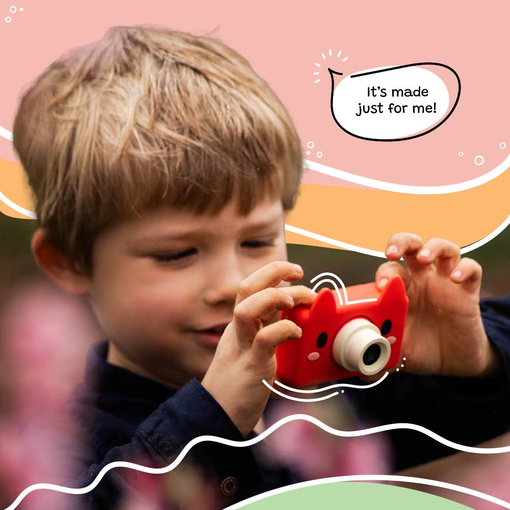 Child holding and using the Kidamento Model C Fox kids camera outdoors with a joyful expression