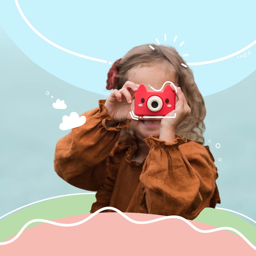 Young girl holding Kidamento Model C Fox kids camera up to her eyes, ready to take a photo