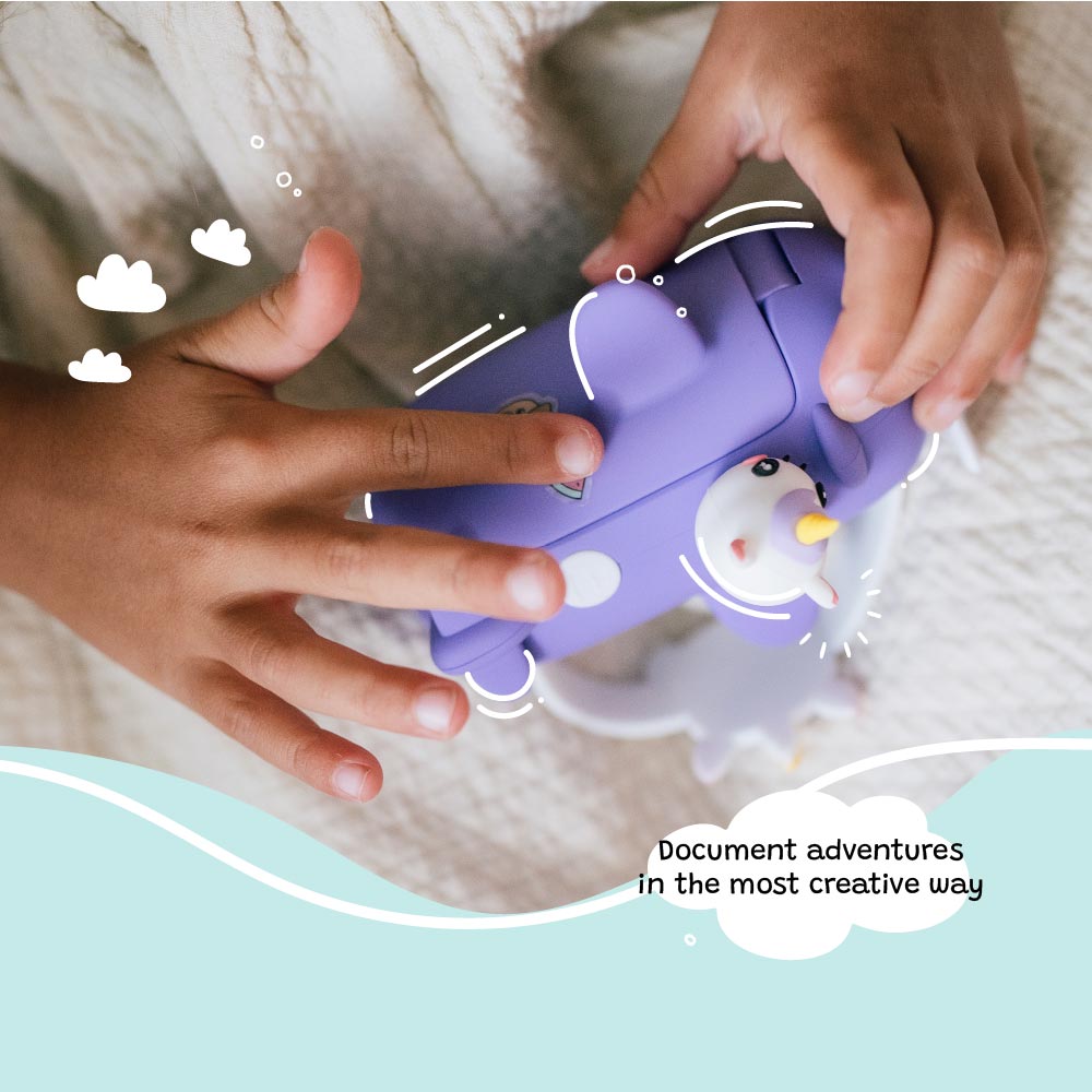Child’s hands holding the Kidamento Model V unicorn kids digital camera. Highlights the purple airplane design with unicorn details—encouraging creative play and storytelling for ages 3 to 9.