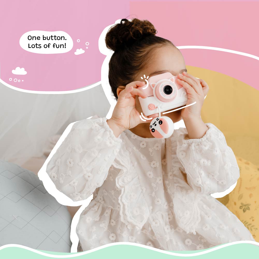 Little girl using the Kidamento Meowie the Cat digital camera, pressing the shutter button to capture fun moments with its adorable pink silicone design.