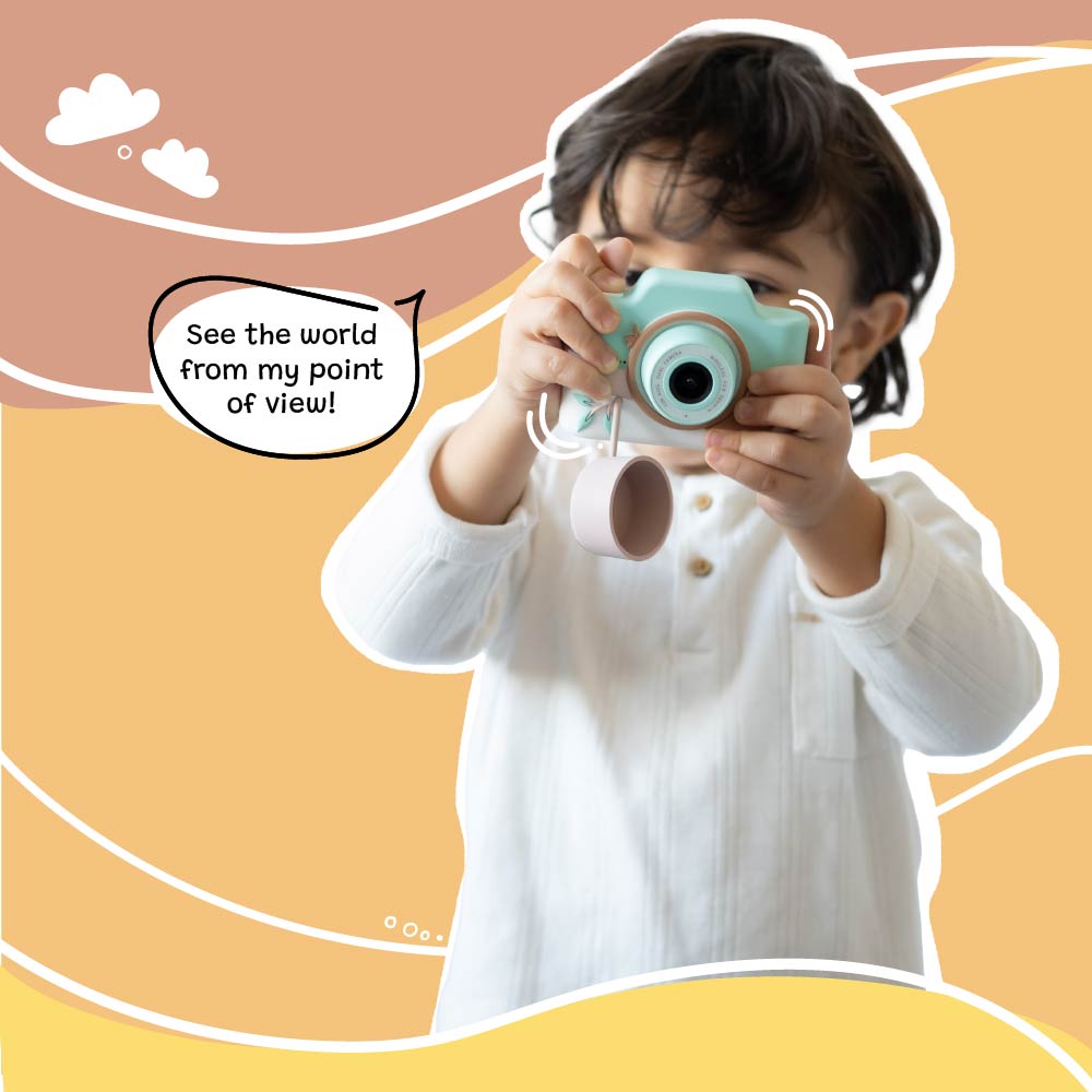 Young child holding and using Kidamento Model K Zippy the Sloth kids digital camera with lens cap hanging, showcasing a child’s point of view
