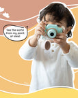 Young child holding and using Kidamento Model K Zippy the Sloth kids digital camera with lens cap hanging, showcasing a child’s point of view