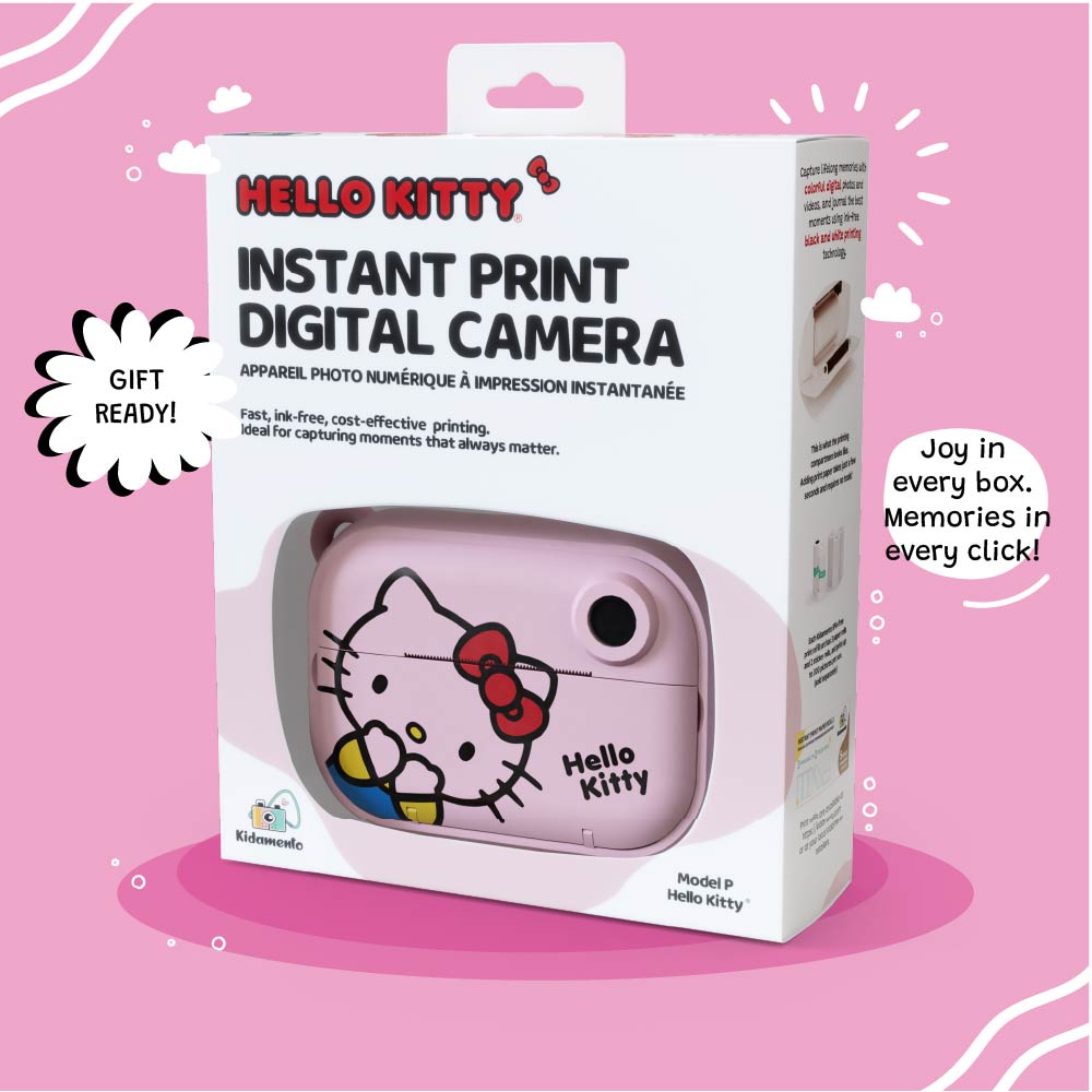 Retail packaging of the Kidamento Hello Kitty Model P instant print digital camera, featuring a window showing the pastel pink camera with Hello Kitty’s face. The box highlights gift readiness, ink-free and cost-effective printing, and memory-making appeal. Tagline at the bottom reads: “Joy in every box. Memories in every click!”