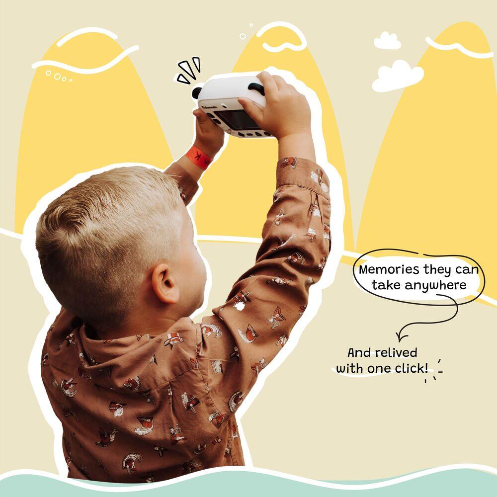 Boy holding up Kidamento Model P Panda kids camera, capturing memories outdoors with playful illustrated background.