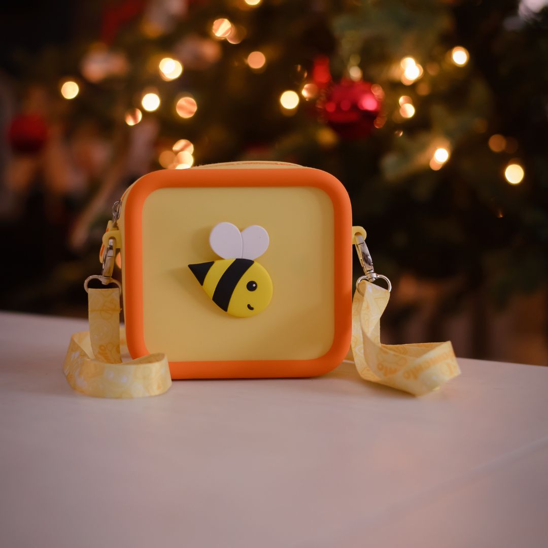 A yellow silicone bag with an orange trim and a bee design.