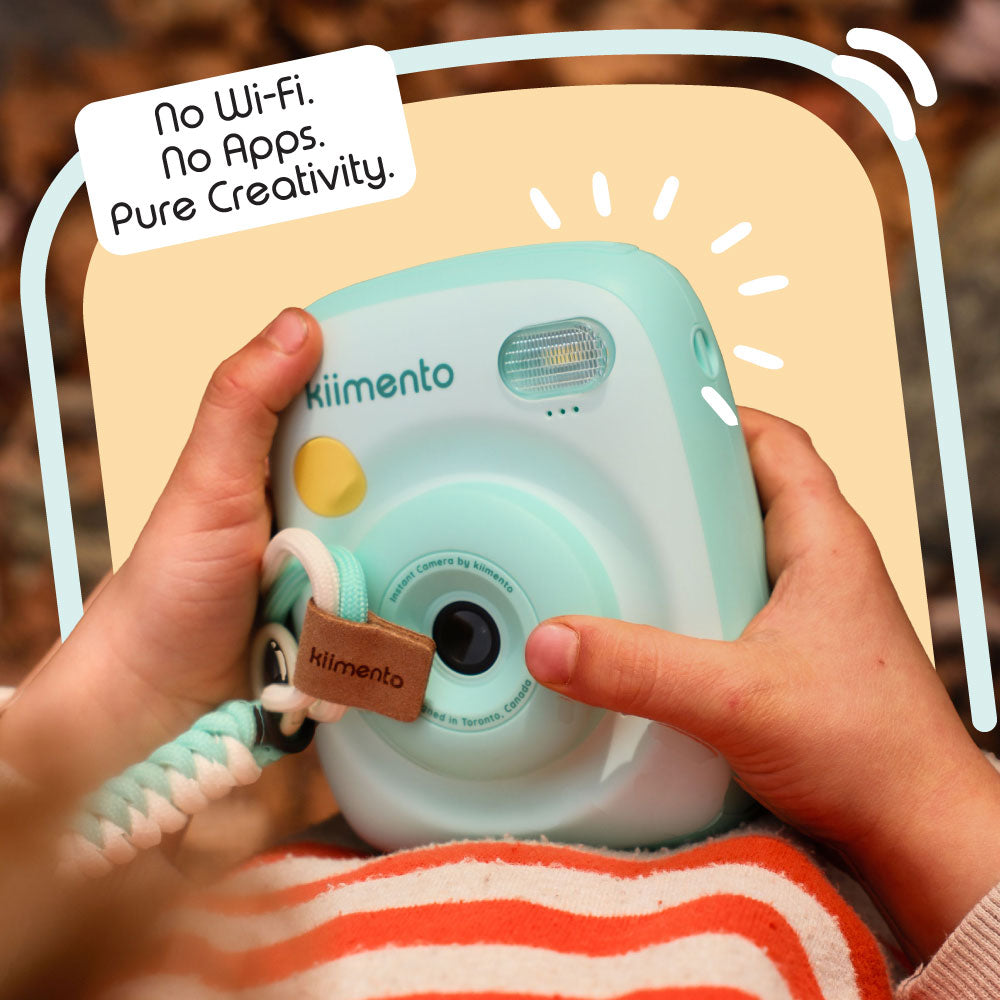 Mint Print Pro Camera held by hands with a hand strap.