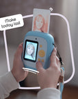 Sky blue instant print camera with a photo coming out of the top.