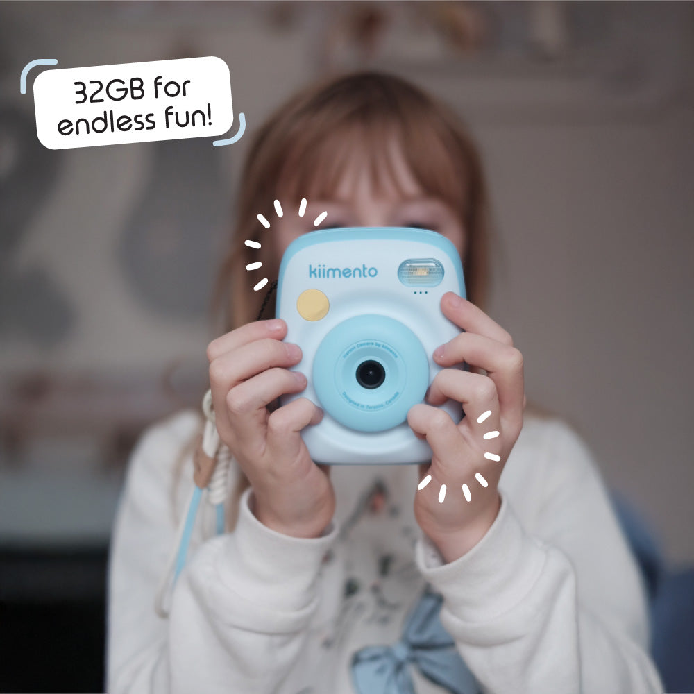 A child holds a sky blue instant print camera with a speech bubble that says "32GB for endless fun!".